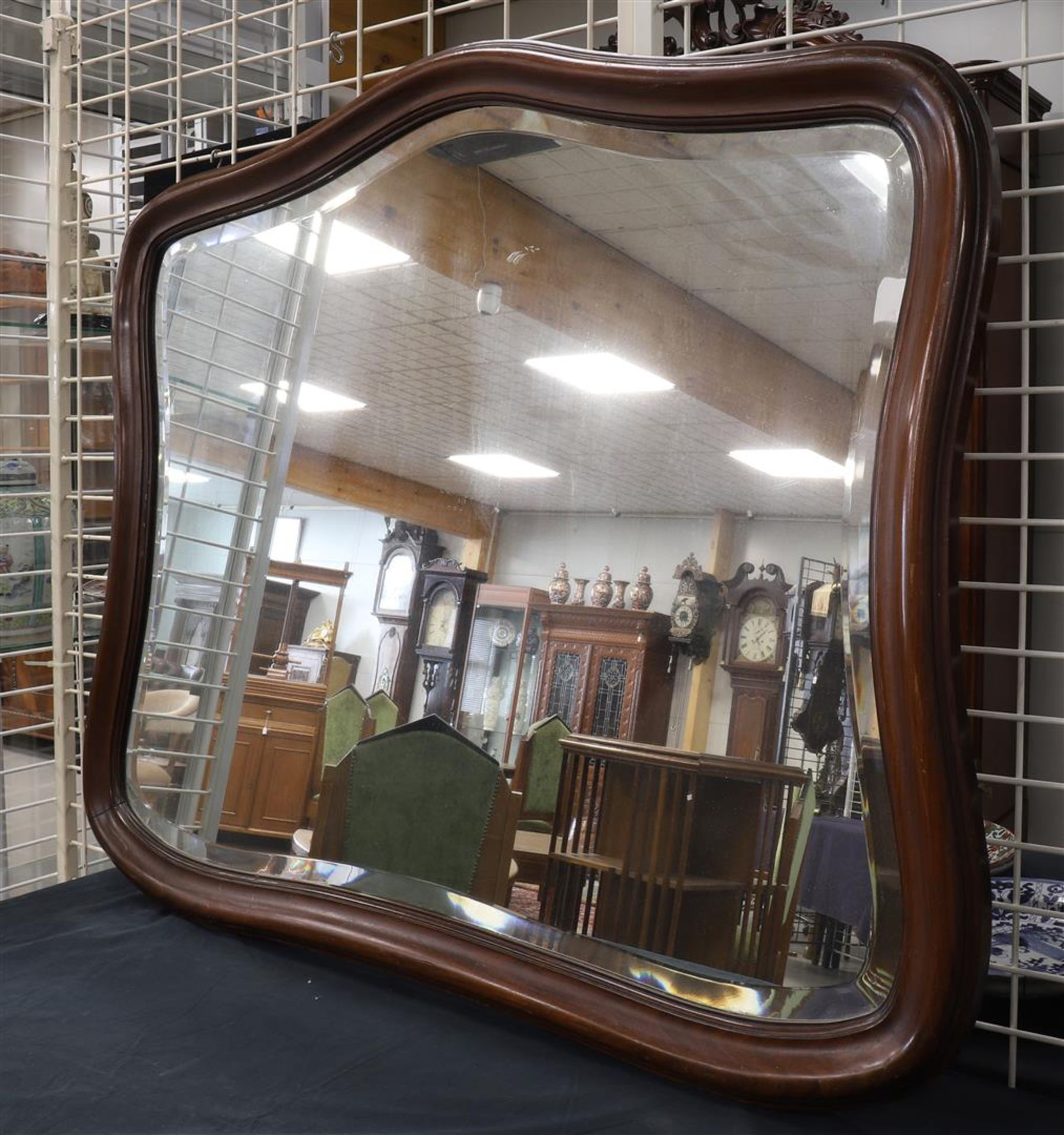 A facet cut mirror in a mahogany profile frame, 1st half of the 20th century, h 90 x w 106 cm.