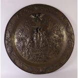 A brass wall plate with chased relief depicting 'Del Gratia', early 20th century, Ø 82 cm.