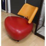 A red and orange leather Leolux Pallone armchair.