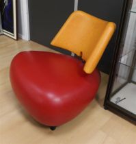 A red and orange leather Leolux Pallone armchair.