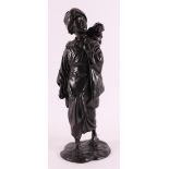 A dark patinated bronze okimono of a woman with a monkey on her shoulder, Japan, 1st half of the