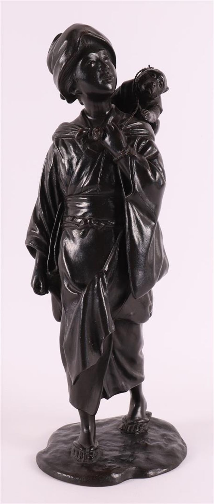 A dark patinated bronze okimono of a woman with a monkey on her shoulder, Japan, 1st half of the