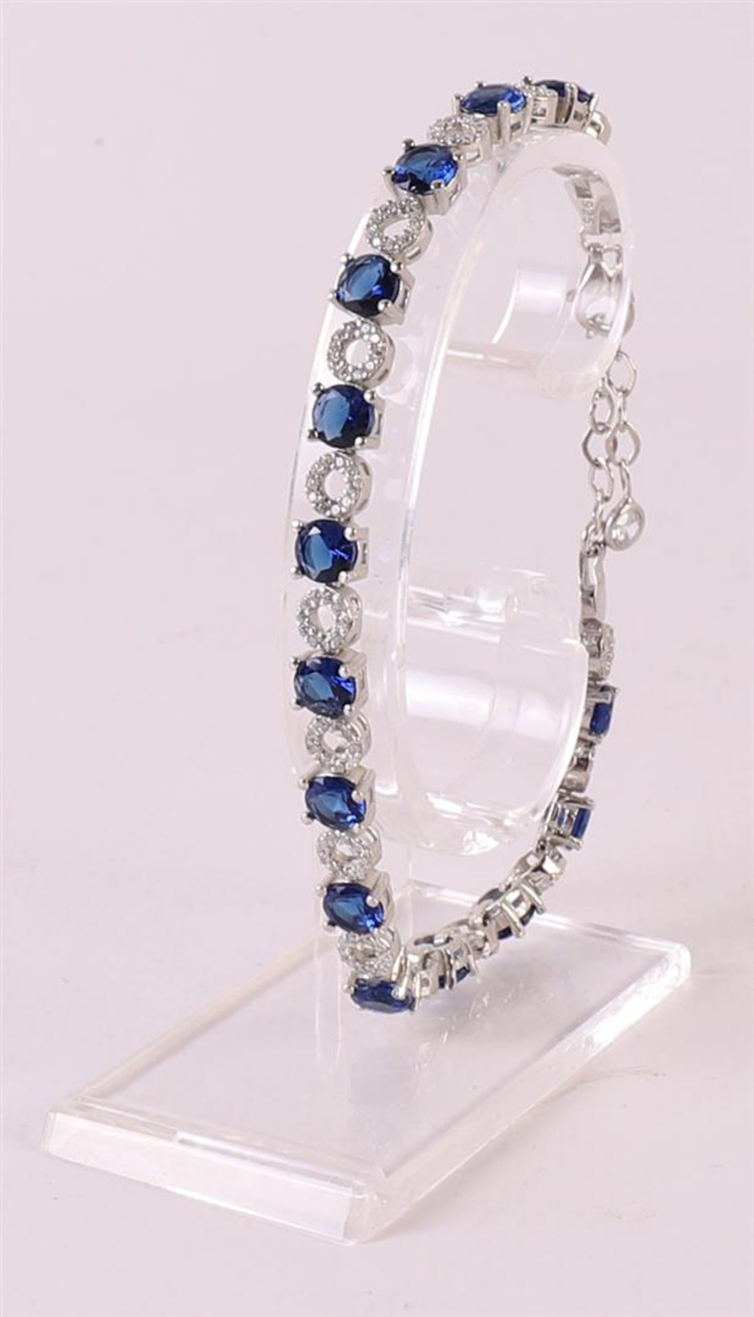 A 1st grade 925/1000 silver tennis bracelet with facet cut blue stones and zirconias.