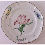 A faience earthenware contoured plate with polychrome decor of a tulip, France, ca. 1750-1780.