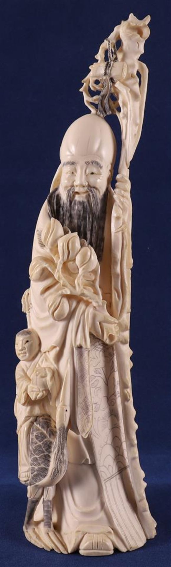 A carved ivory Shou Lao with staff and peaches in his hand, at his side a fool on a crane, China,