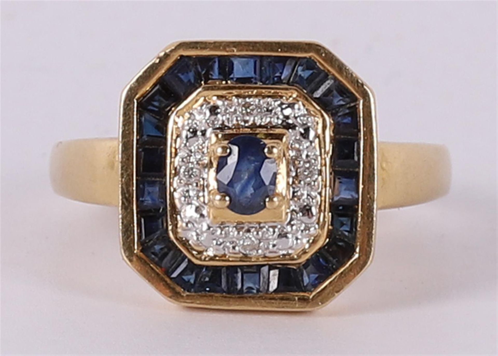 An 18 kt 750/1000 gold ring with 4 brilliants and 23 facet cut blue sapphires. Ring size 18.5 mm.