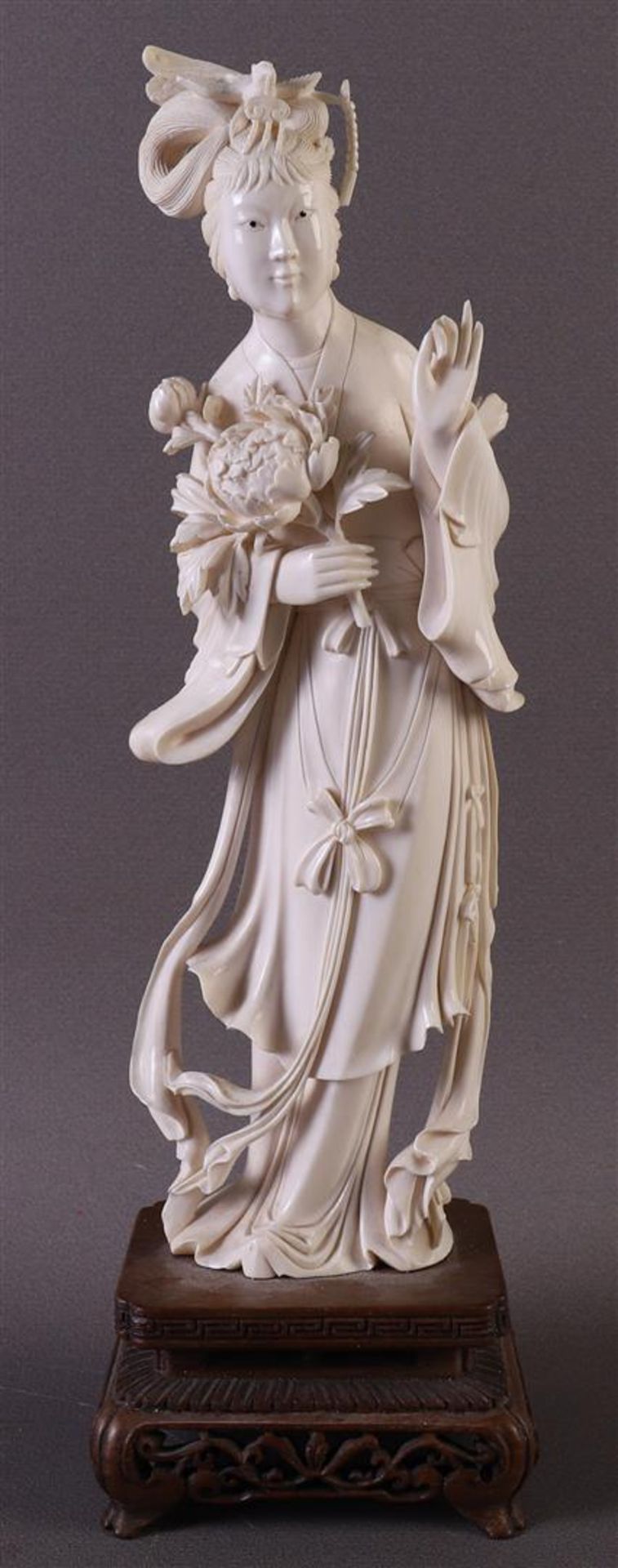 A carved ivory standing Guanyin with a lotus flower in her hand, China, Republic, ca. 1920, weight