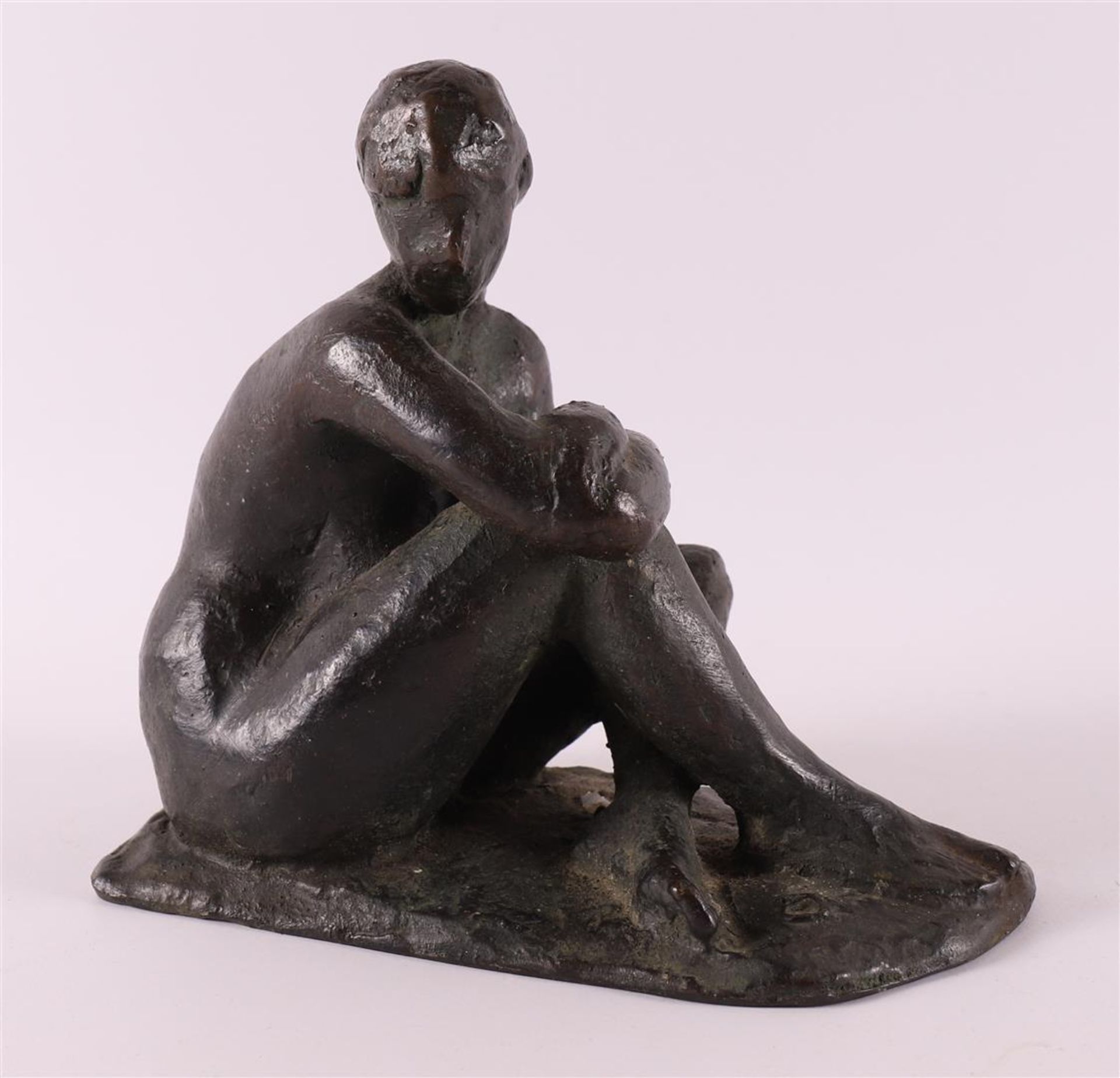 A brown patinated bronze sculpture of a seated female nude, 1918-1993.