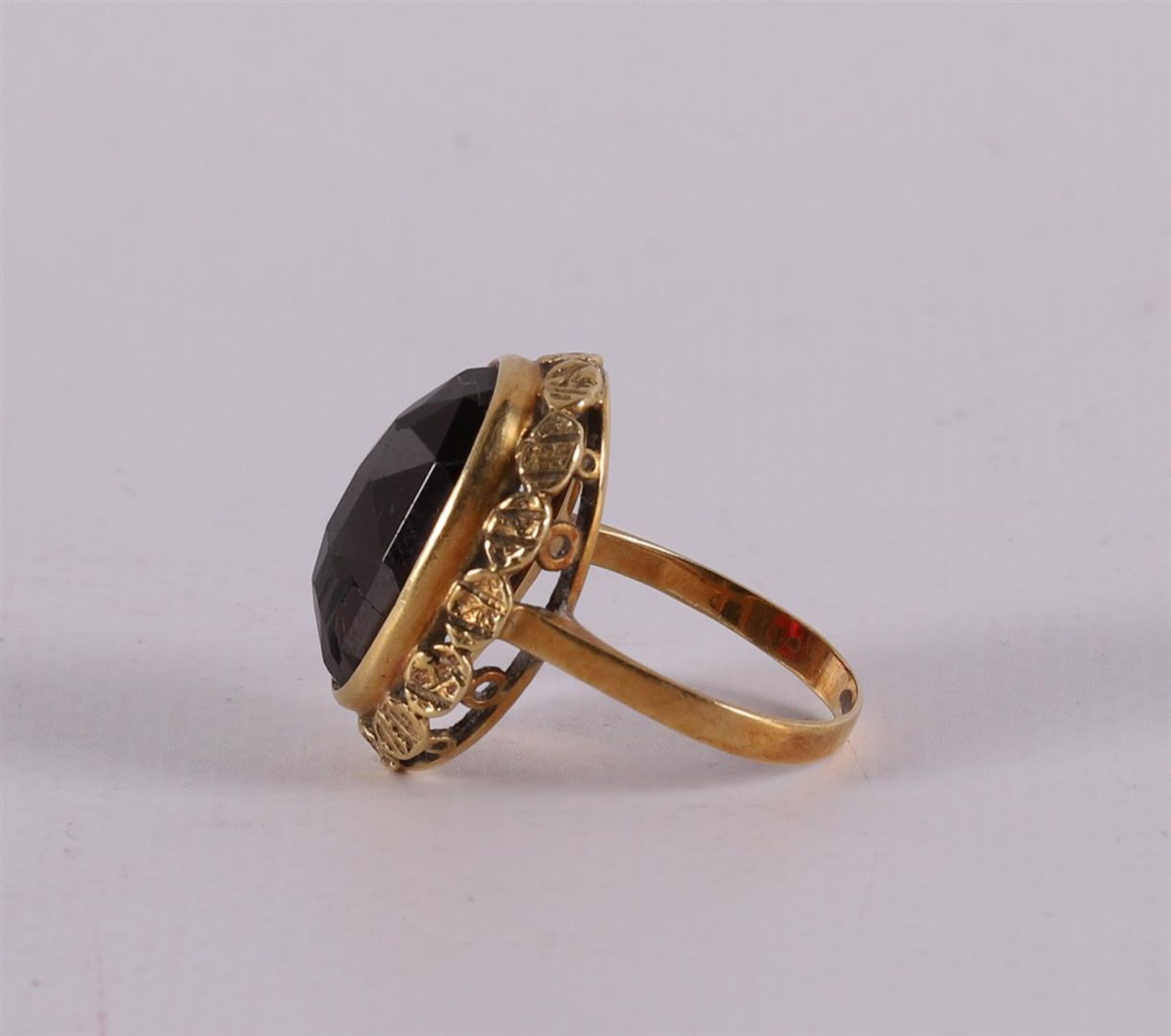 A 14 kt yellow gold ring, set with a faceted oval garnet. - Image 2 of 2