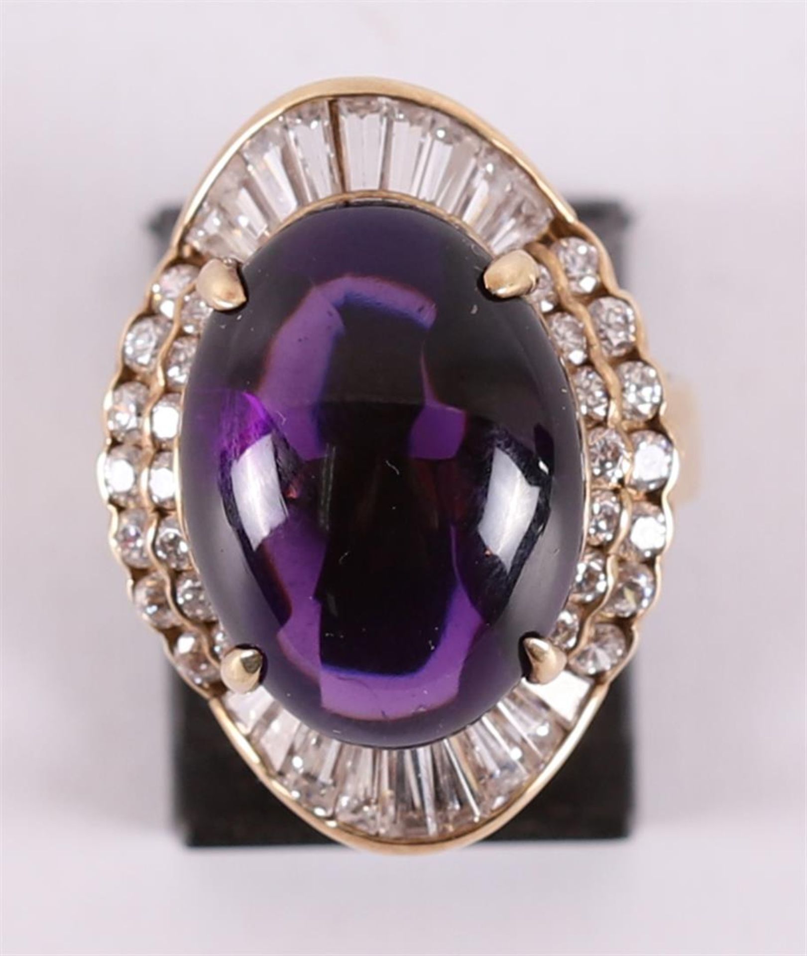 A 14 kt gold ring with a cabochon cut amethyst.