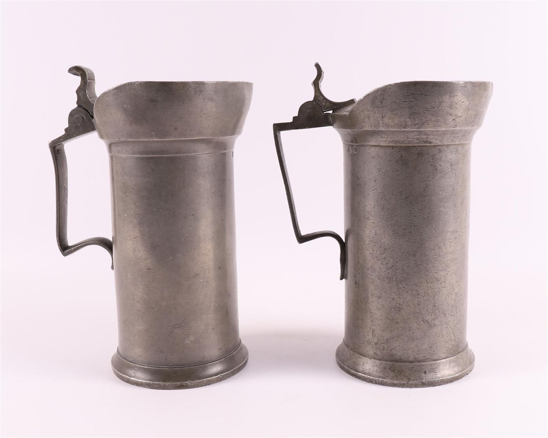 Two blank pewter one liter measuring jugs with flap lid, Holland 19th century.