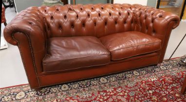 A two-seater Chesterfield sofa and armchair with ottoman, 20th century.