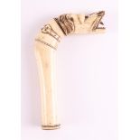 A carved bone walking stick handle in the shape of a dog, 19th century