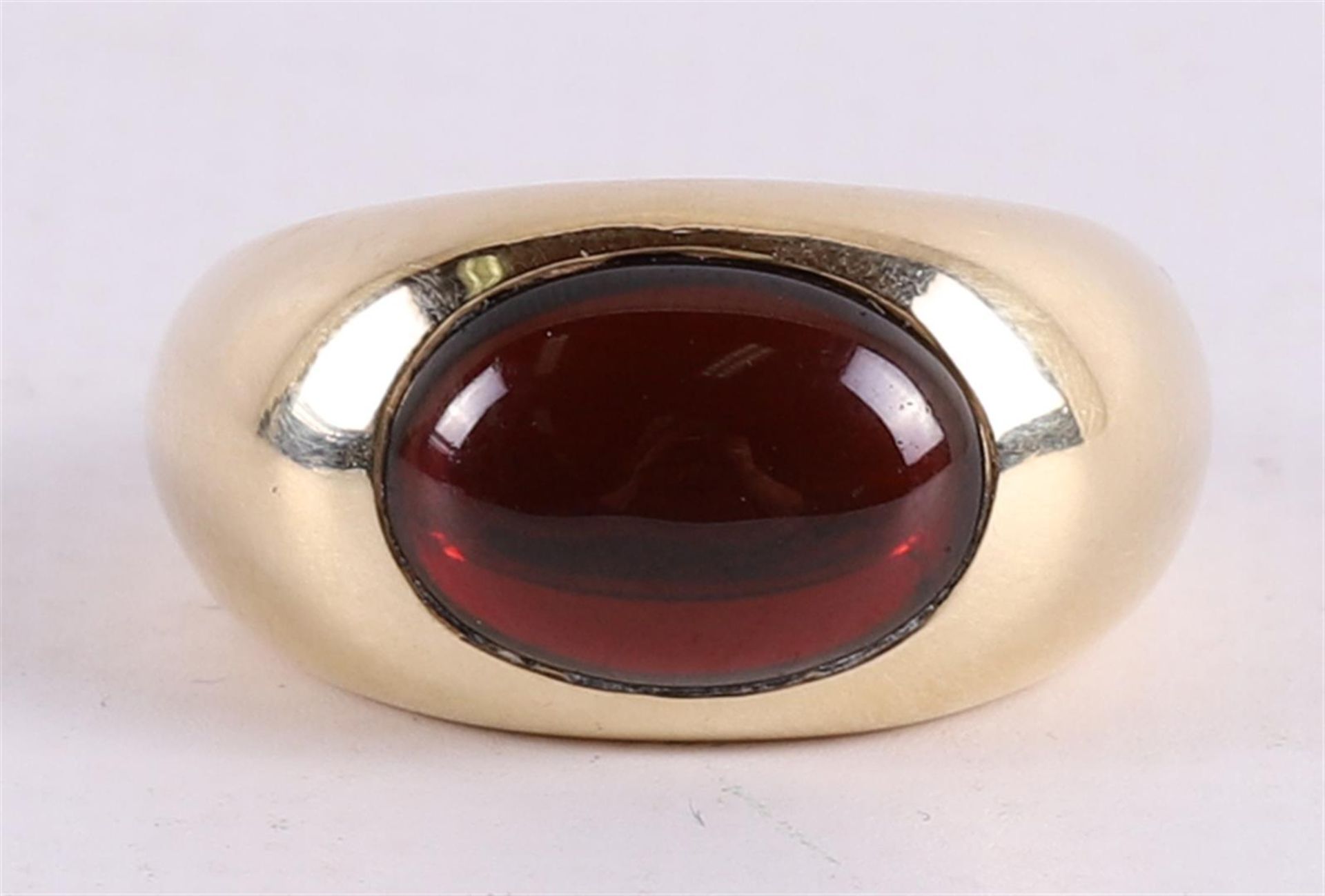 A 14 kt 585/1000 yellow gold ring, set with a cabochon cut red colored stone