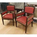 A pair of walnut armrest armchairs with red striped fabric upholstery,