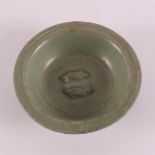 A green glazed celadon bowl with relief decoration of two fish, China,