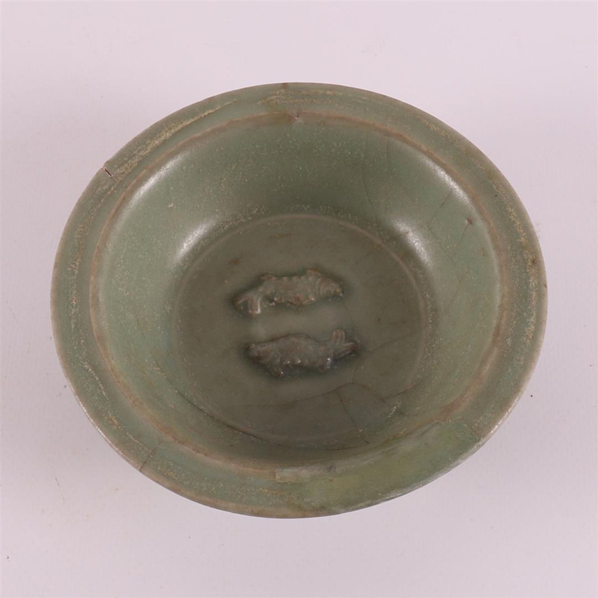 A green glazed celadon bowl with relief decoration of two fish, China,