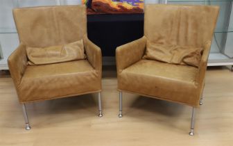 A pair of designer armchairs, brown leather upholstery.