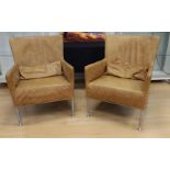 A pair of designer armchairs, brown leather upholstery.