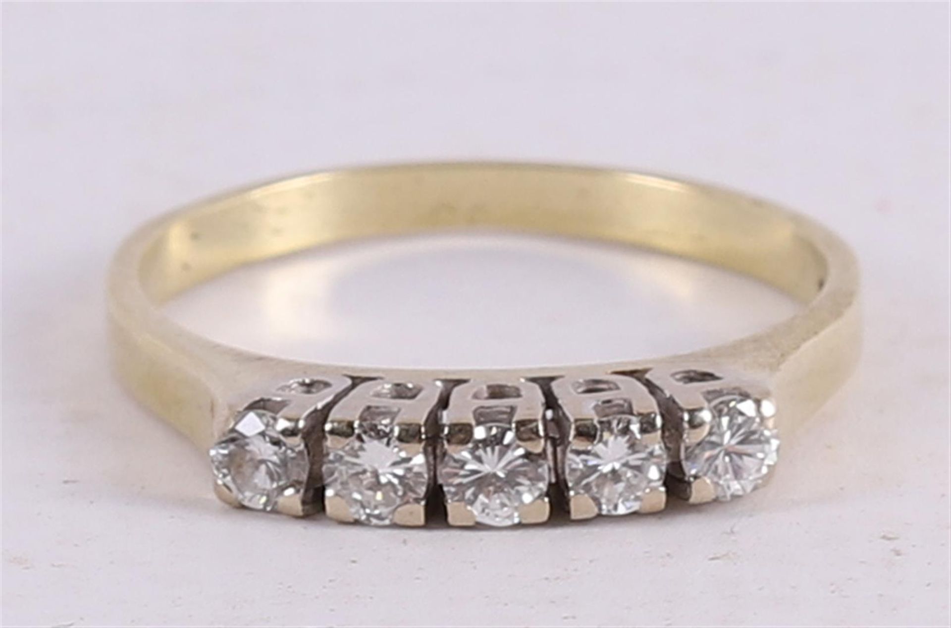 A 14 kt 585/1000 yellow gold row ring, set with five brilliant cut diamonds.