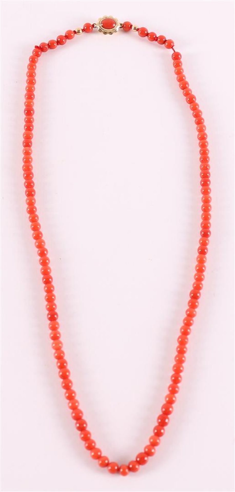 A necklace of red coral and a 14 carat gold lock with a red coral and gold.