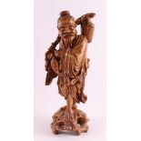 A carved wooden sculpture of a fisherman, China, around 1900.