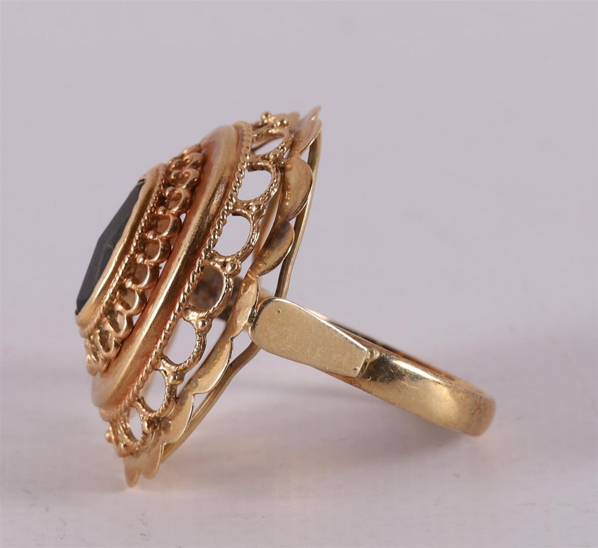A 14 kt yellow gold ring, set with a faceted oval garnet. - Image 2 of 2