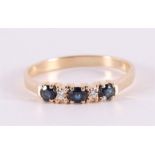 A 14 kt gold row ring with 3 facet cut blue sapphires and 2 brilliants
