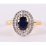 A 9 kt BWG ring with facet cut blue sapphire, flanked by zirconias