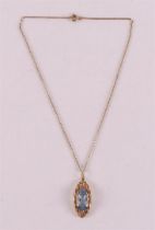 A 14 kt yellow gold design pendant, set with faceted blue color stone.