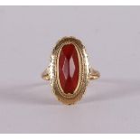 A 14 kt yellow gold ring, set with faceted oval carnelian.