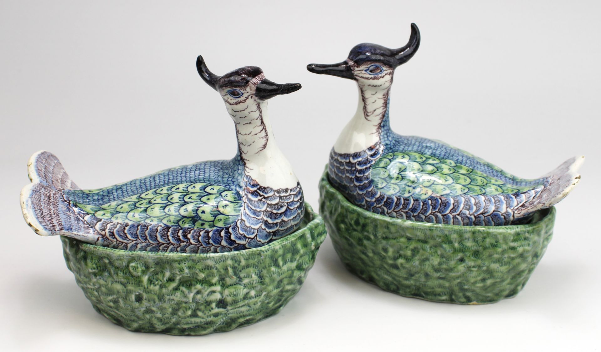 A pair of Delft polychrome pottery lapwing covered dishes