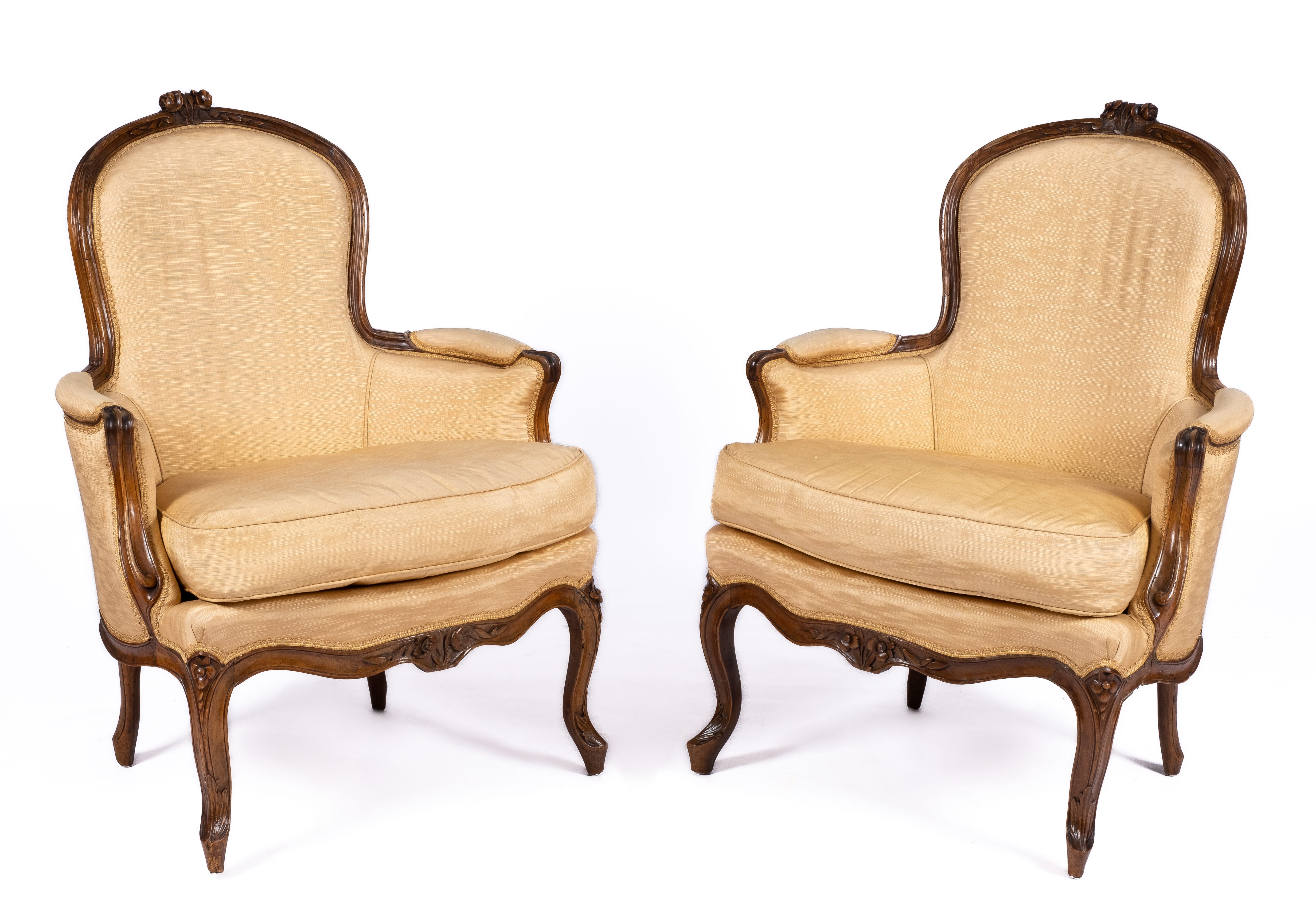 A pair of Louis XV carved walnut bergères