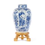 A large Dutch Delft blue and white covered vase on wooden stand