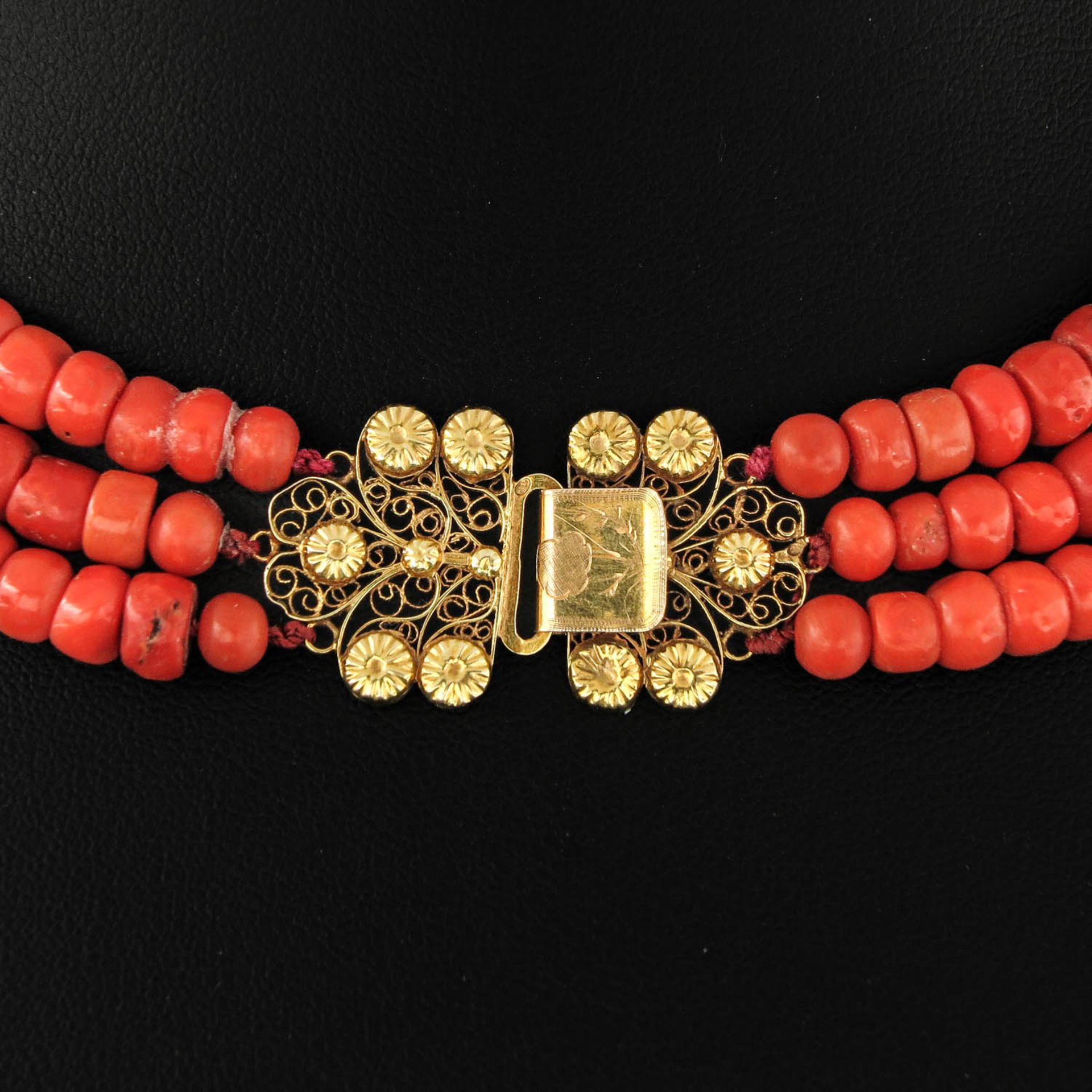 A Three Strand Red Coral Necklace on Gold Clasp