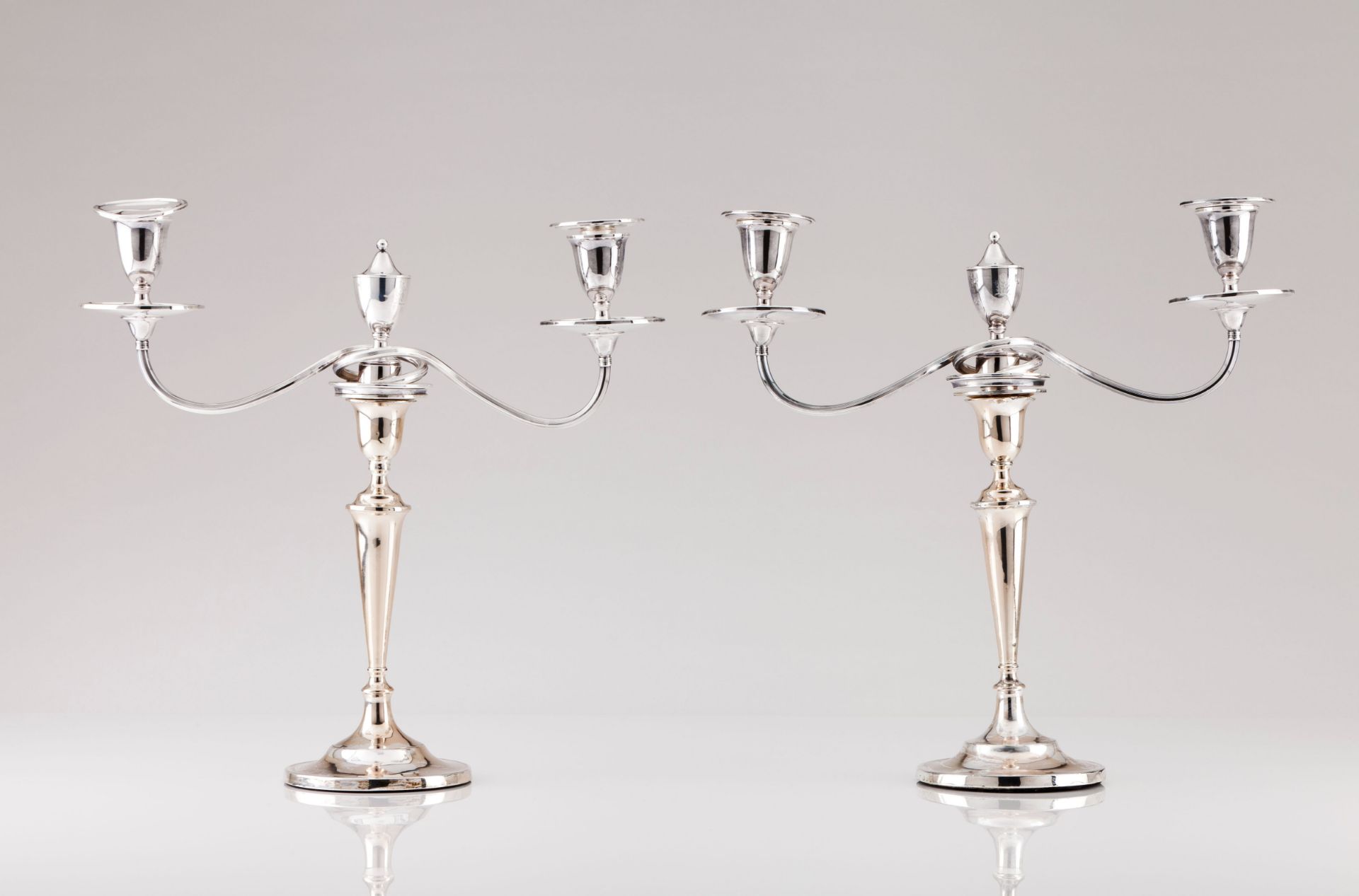 A pair of neoclassical candlestands with three branch serpentines