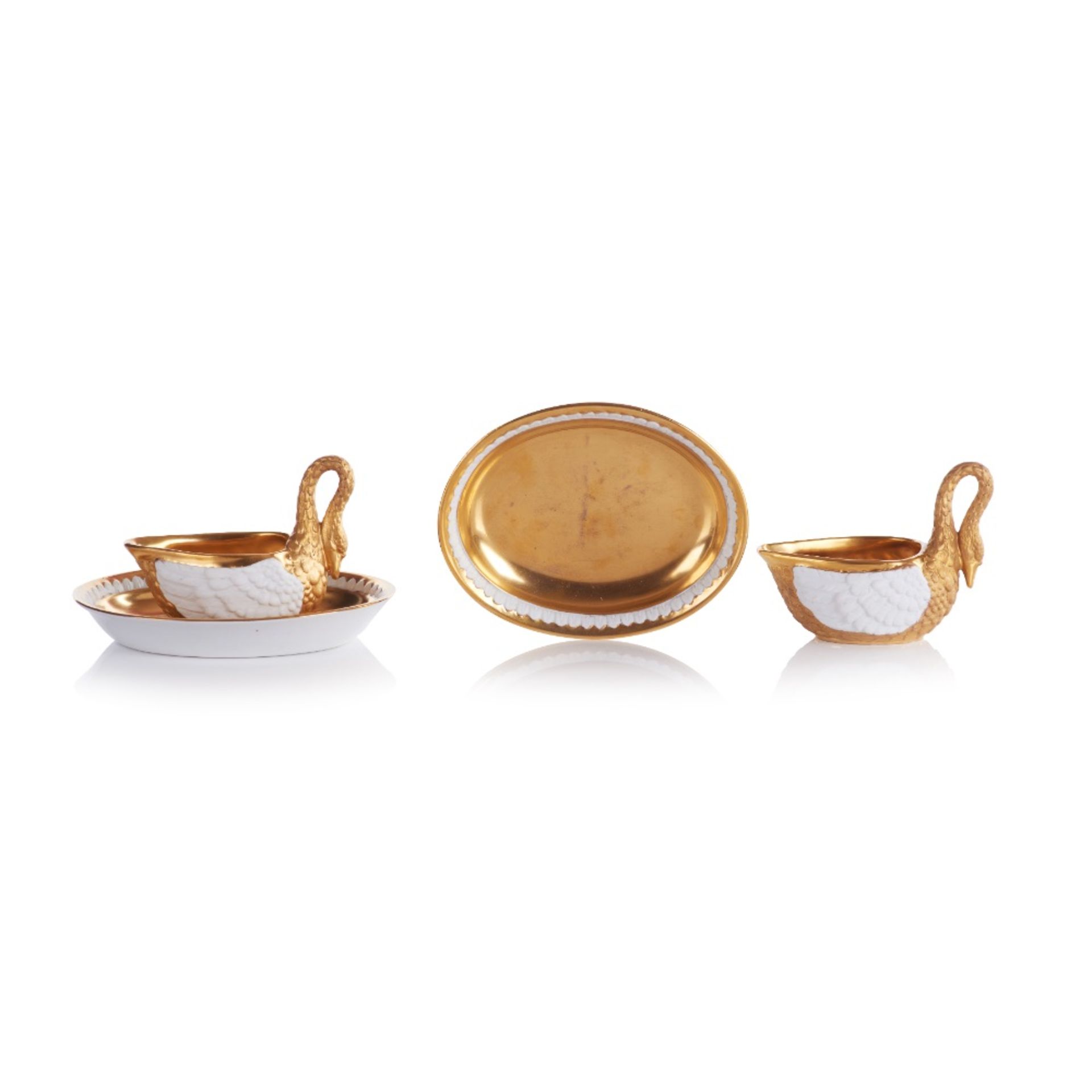 A set of two swan shaped cups with saucers