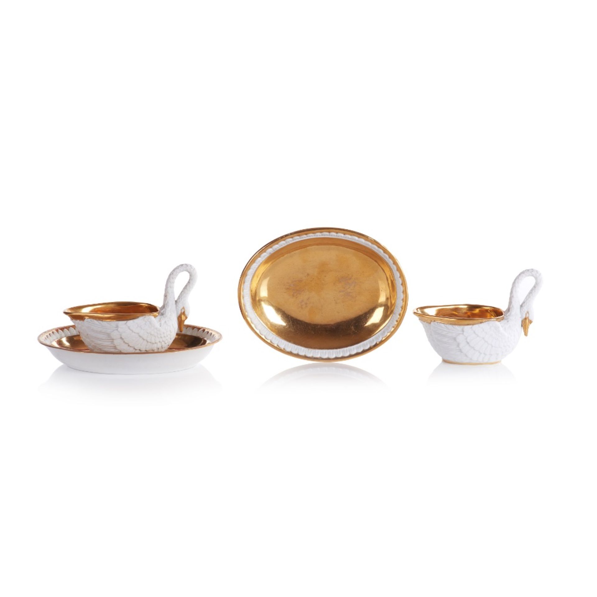 A set of two swan shaped cups with saucers