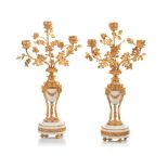 A pair of Louis XV style three branch candelabra, White marble with gilt spelter ram's heads and