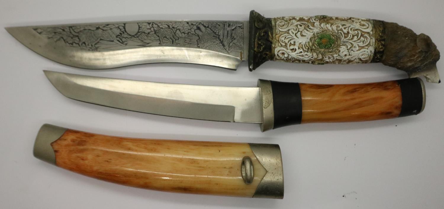 A modern Bowie style hunting knife with engraved blade and carved handle (lacking scabbard),
