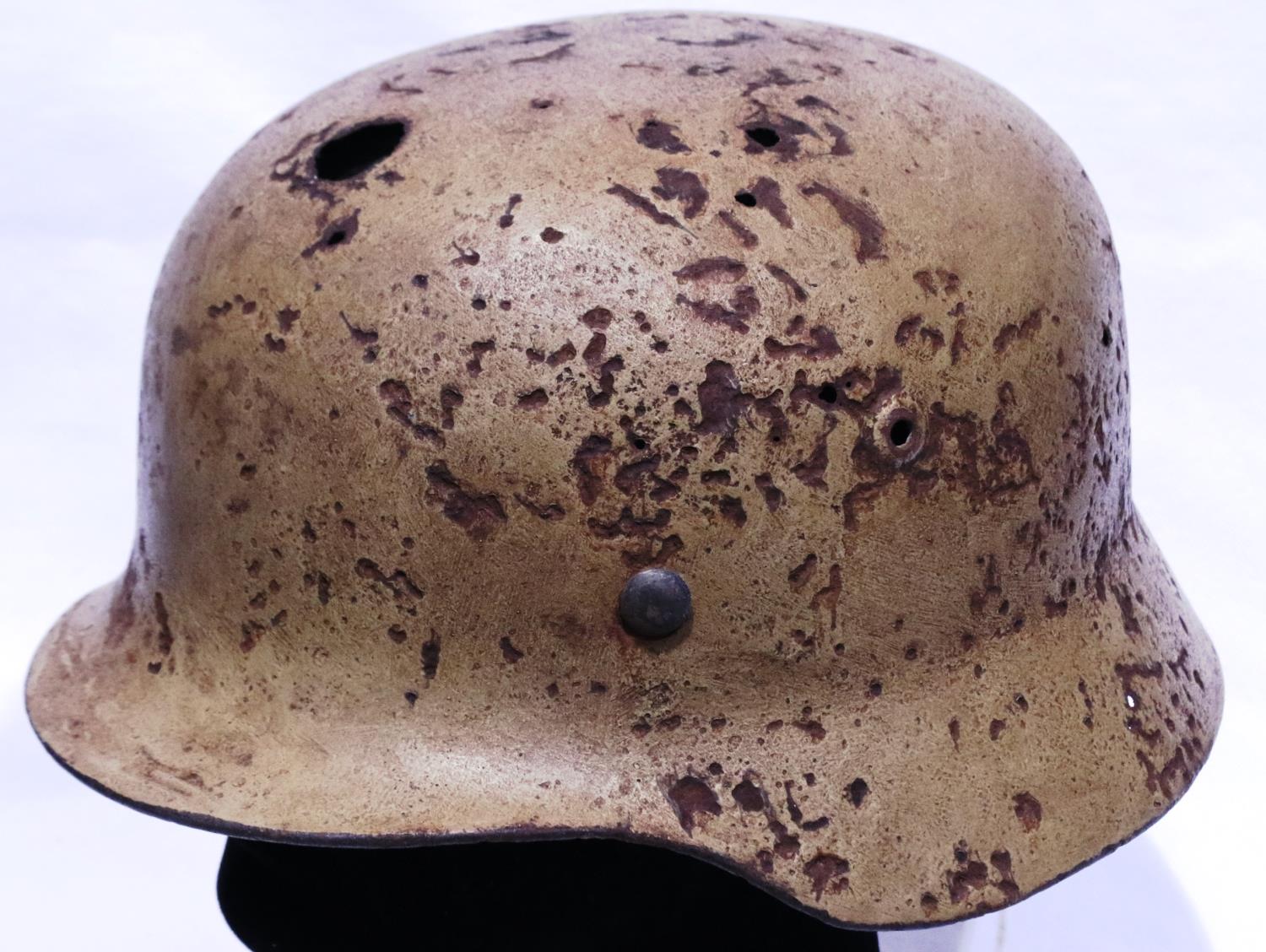 WWII period German Afrika Korps M40 helmet, large circular hole at front, rust and pitting