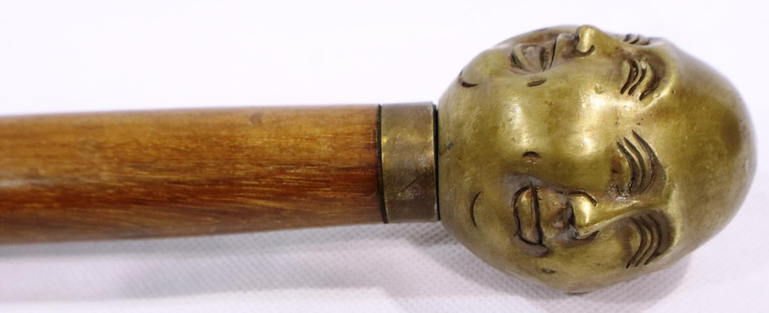 Brass four faced Buddha handled walking stick, L: 94 cm. P&P Group 3 (£25+VAT for the first lot