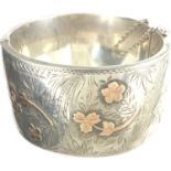 Hallmarked silver engraved cuff bangle with gold highlights and safety chain, D: 65 mm, 51g. P&P