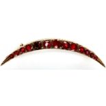 Victorian 9ct rose gold crescent brooch, set with thirteen graduated red stones, L: 50 mm, 2.9g. P&P