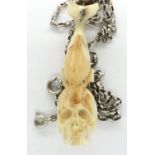 Meerschaum skull and dolphin form pendant, on a 925 silver neck chain, L: 50 cm. P&P Group 1 (£14+