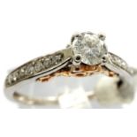 18ct white gold, diamond set solitaire ring with diamond chip shoulders and rose gold wash, size