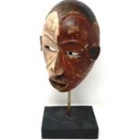 Carved wooden Tribal mask on a wooden stand, overall H: 47 cm. P&P Group 3 (£25+VAT for the first