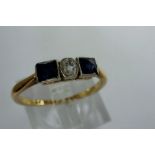 18ct gold trilogy ring set with central diamond flanked by two square cut sapphires, size L, 1.8g.