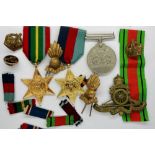 British WWII Defence medal, two restrike stars (Pacific & 1939-45), Royal Artillery cap badge,