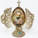 Ornate gilt Faberge style filigree egg with rotating wooden icon inside and turquoise cabochons,